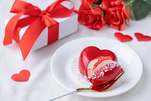 Valentines day. heart shaped glazed valentine cake and flowers in bed