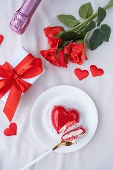 Valentines day. heart shaped glazed valentine cake and flowers in bed