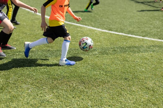Children's football. Ball game. Children at sports competition in summer. Active lifestyle.