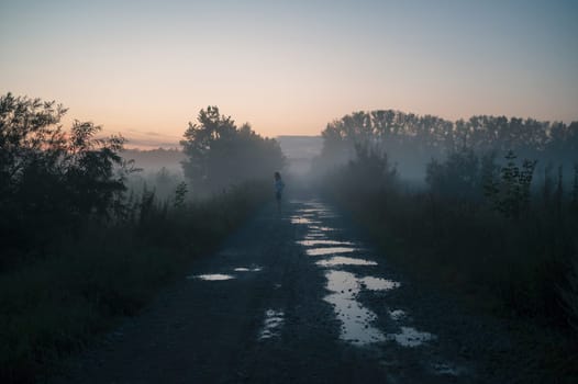 Woman in beautiful misty fog, summer landscape