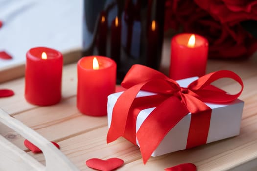 Valentines day. valentine gift box and candles in wooden tray