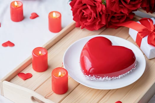 Valentines day. heart shaped glazed valentine cake and candles in wooden tray