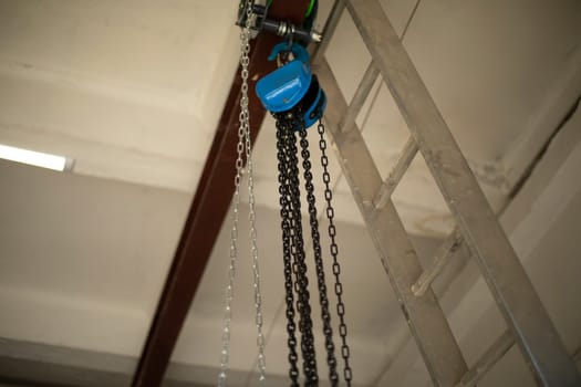 Chain on ceiling. Chains hang on steel beam. Forklift mechanism.