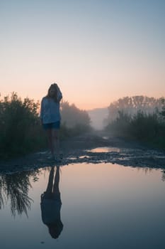 Woman in beautiful misty fog, summer landscape