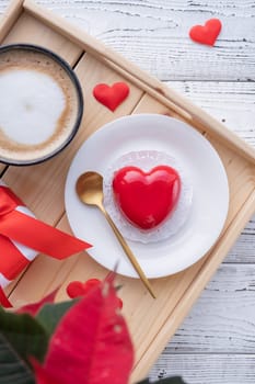 Valentines day. heart shaped glazed valentine cake and flowers in bed