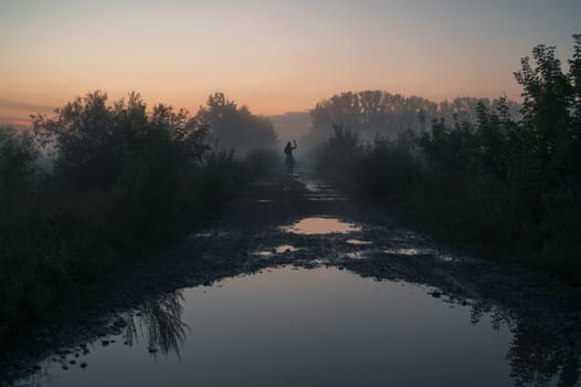 Woman in beautiful misty fog, summer landscape