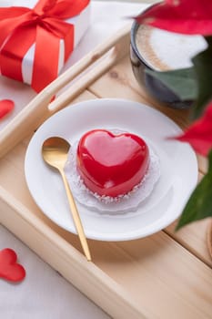 Valentines day. heart shaped glazed valentine cake and flowers in bed