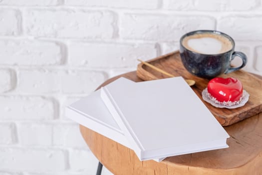 Valentines day. blank books with heart shaped glazed valentine cake in wooden tray