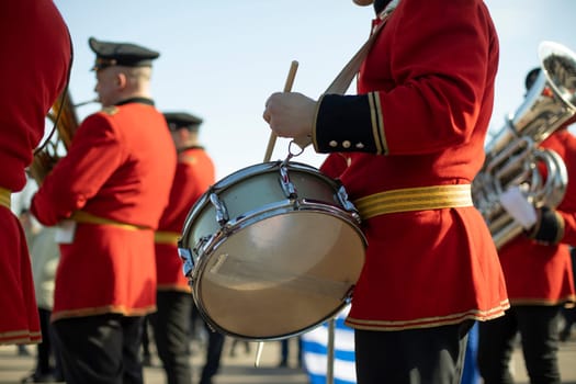 Drummer at parade in red clothes. Drumming. Percussion musical instrument.