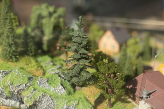 Town in mountains in miniature. Trees made of plastic. Toy land. Game world.