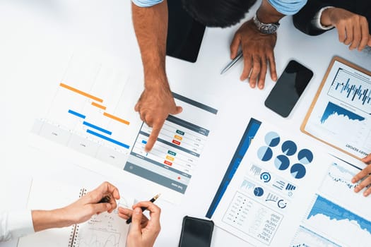 Top view project manager communicate and collaborate with team using project management software, tracking progress of project task and making schedule plan at meeting table. Prudent