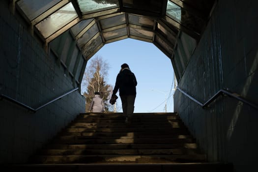 Man comes out of tunnel. Silhouette of girl walking down steps. Pedestrian crossing underground.