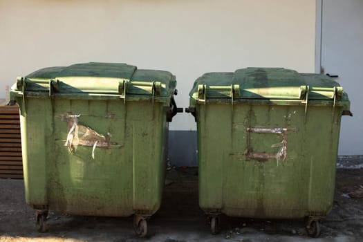 Green garbage cans. Containers for waste on street. Place of removal of trash.