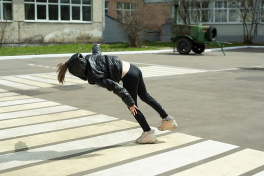 Child falls on asphalt. Beginning of fall. Girl stumbled.