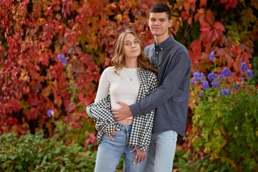 Young Cute Female Hugs Boyfriend. In Autumn Outdoor. Lovers Walking in Park. Attractive Funny Couple. Lovestory in Forest. Man and Woman. Cute Lovers in the Park. Family Concept. Happy Couple.