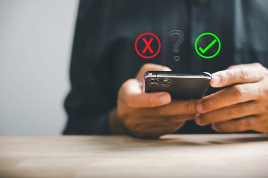 Using smartphones businessman reveals right and wrong icons for yes or no decision-making. Communication of choice and expertise. Think With Yes Or No Choice.