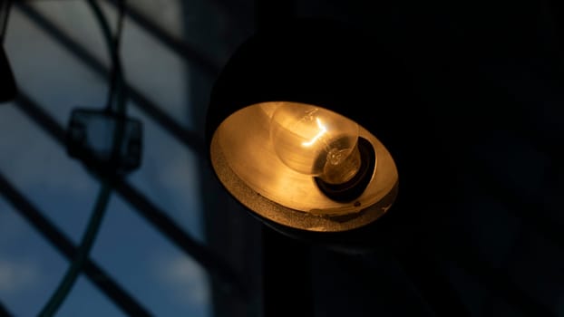 Table lamp in room. Light on table. Old type incandescent lamp. Interior details.