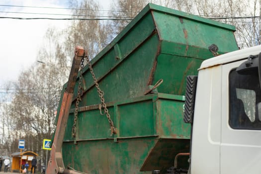 Transportation of container. Garbage truck. Steel container on transporter.