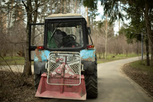 Harvesting equipment in park. Heavy technical with large wheels. Soviet tractor.