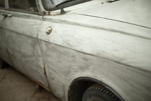 Retro car in gray paint. Transport details. Wing of wheel of machine. Transport in parking lot. Russian car.