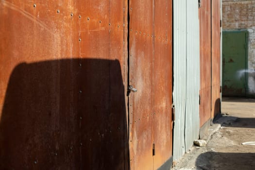 Rusty gates in industrial area. Warehouse details. Steel gates. Rust on metal.