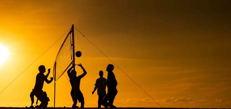 A group of people playing a game of volleyball