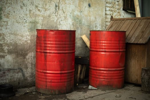 Red barrels of fuel. Steel barrels in industrial area. Cesternes in yard of warehouse. Red oil tanks.