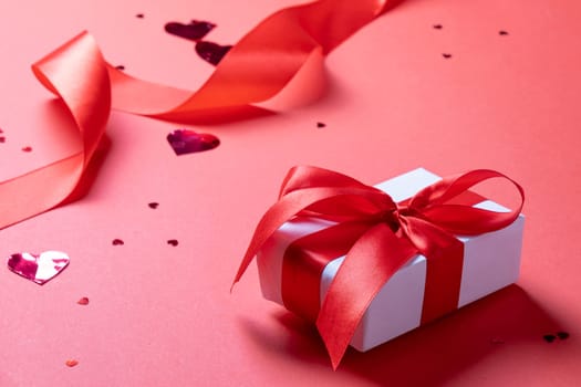 Valentines day. valentine red ribbons, confetti and gifts on red background