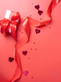 Valentines day. valentine red ribbons, confetti and gifts on red background