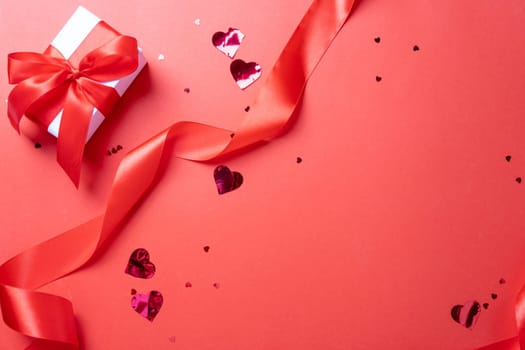 Valentines day. valentine red ribbons, confetti and gifts on red background