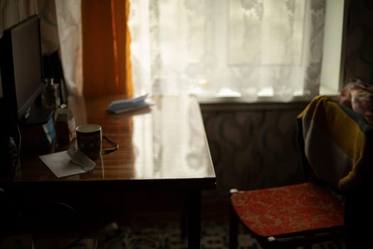 Table and chair. Interior of old apartment in Eastern Europe. Simple interior of house. Wooden furniture in house.