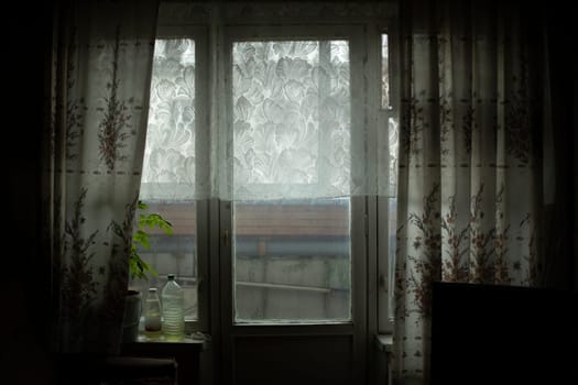 Window in room. Curtains on window. Details of interior of old apartment in Russia.