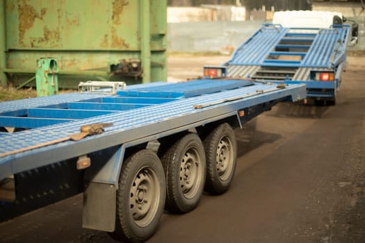 Pltatform for car towing. Freight transport. Blue trailer. Truck parts.