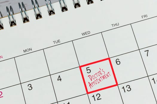 Red mark on the calendar at 5 for reminder of doctor's appointment. Health concept.