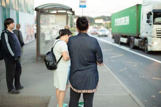 People are waiting for bus. Waiting for transport at bus stop. People in city.