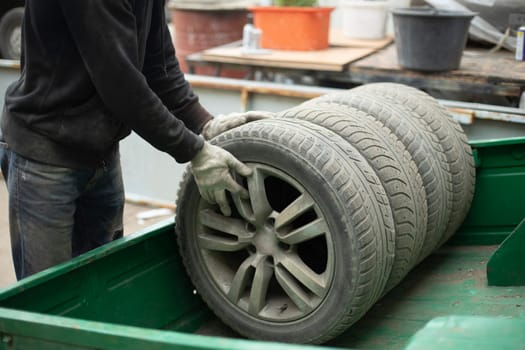 Wheel from car. Wheel loading. Details of removing wheels from car. Tire fitting in garage.