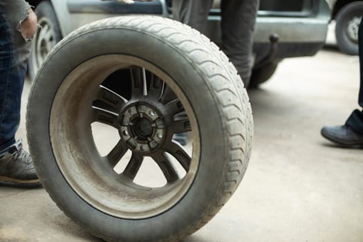 Wheel from car. Wheel loading. Details of removing wheels from car. Tire fitting in garage.