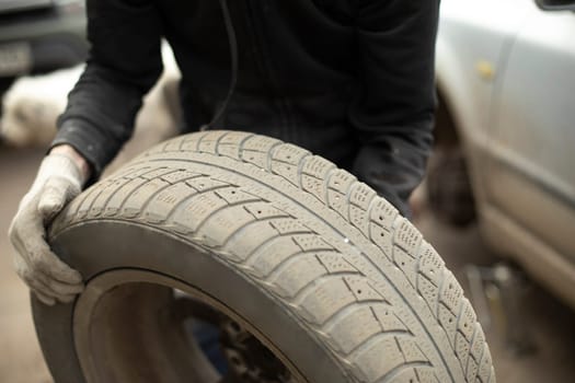 Wheel from car. Wheel loading. Details of removing wheels from car. Tire fitting in garage.