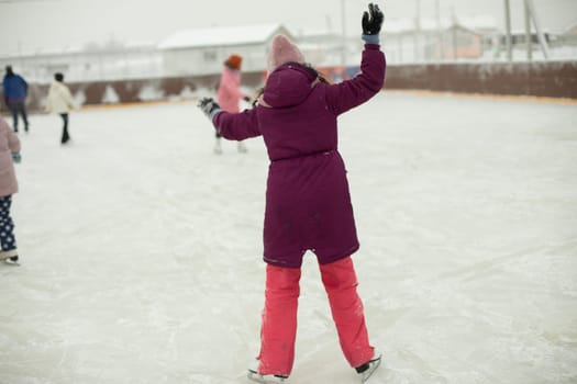 Girl on skates. Winter holidays. Ice skating. Sports details. Exercise on ice. Figure skating.