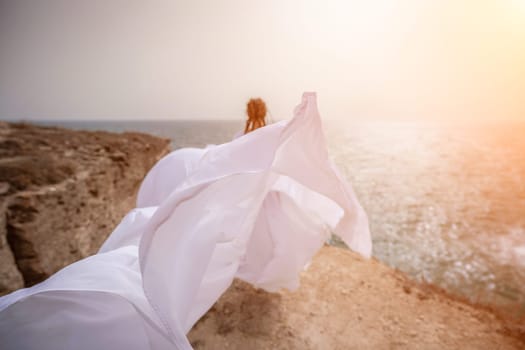 Woman sea white dress. Happy freedom woman on the beach enjoying and posing in white dress. Rear view of a girl in a fluttering white dress in the wind. Holidays, holidays at sea