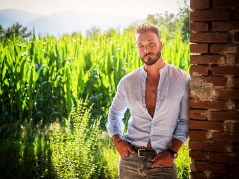 A man standing in front of a brick wall