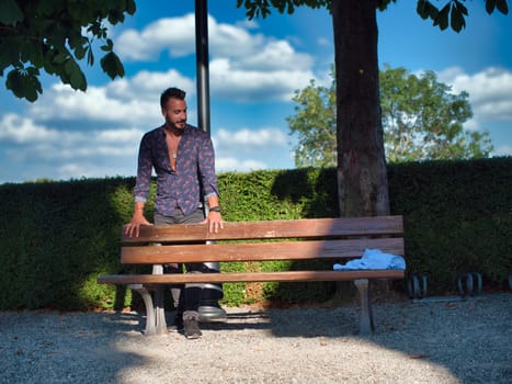 A man sitting on a bench in a park