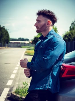 A man standing next to a parked car