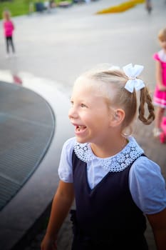 Little girl of elementary school student in modern school uniform outdoors. Female child schoolgirl going to school. Back to school in september 1