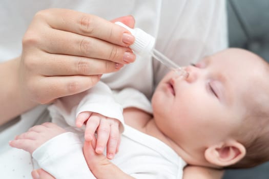 Gently and with precision, mother uses a pipette to bury her sleeping baby's nose with care in her