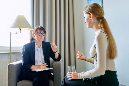 Mature female psychologist counselor therapist working with young woman sitting talking in office. Meeting therapy, psychology psychotherapy treatment support mental health concept