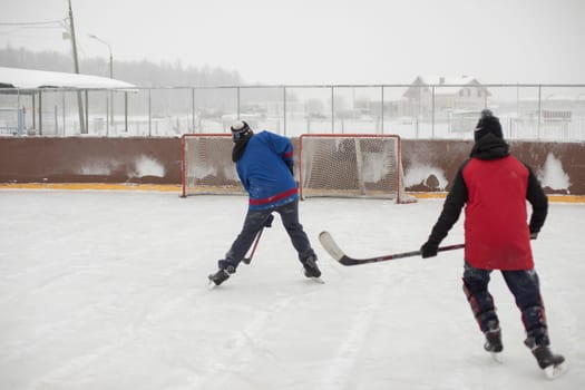 Playing hockey. Guys skate. Hockey player with stick. Ice skating. Ice rink in winter.