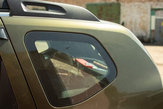 Rear side window of car. Small window in transport. Machine parts. Transport in parking lot.