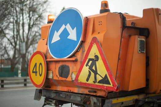 Road signs on special equipment. Car for cleaning. Construction warning sign.