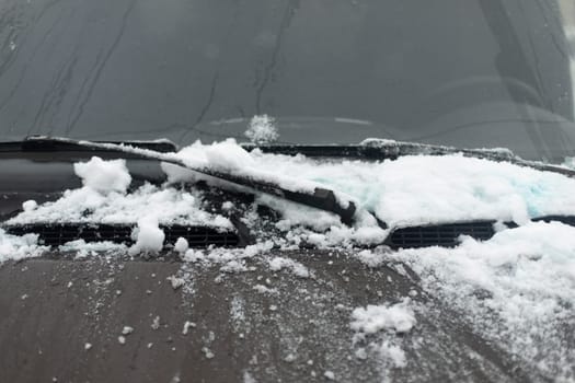 Snow by car. Car glass in winter. Transport details.